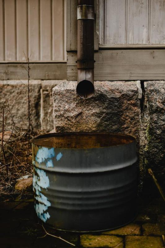 Récupérateur d’eau de pluie placé sous une descente de gouttière